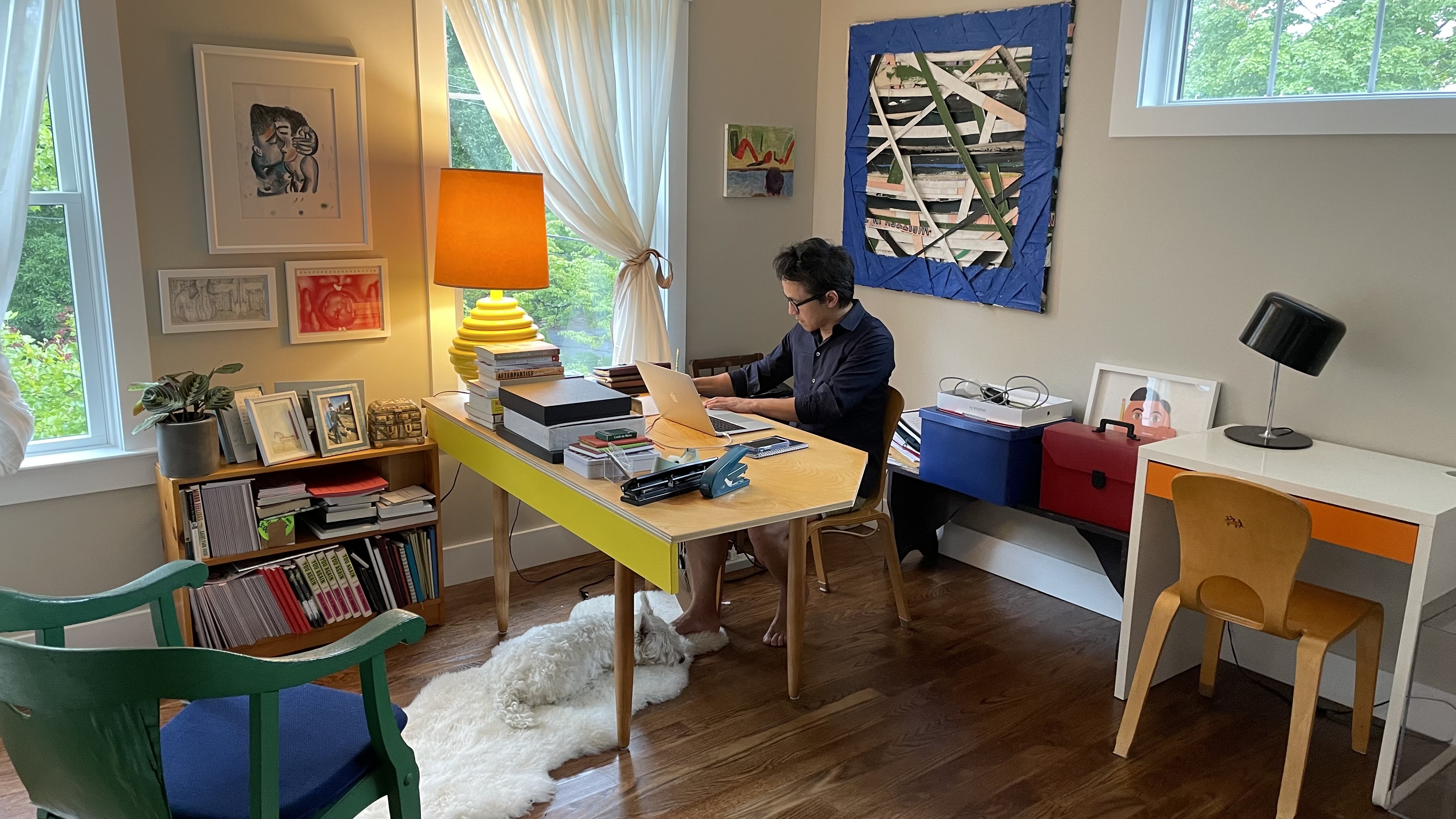 Quang Bao in his home office with work by Pau Atela and Matt Chambers behind him